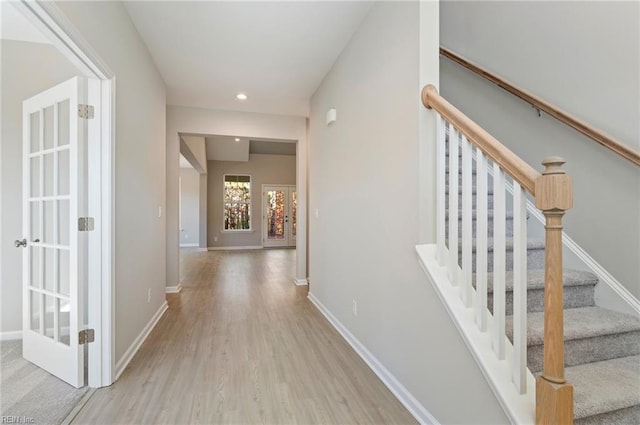 corridor with stairs, recessed lighting, baseboards, and wood finished floors