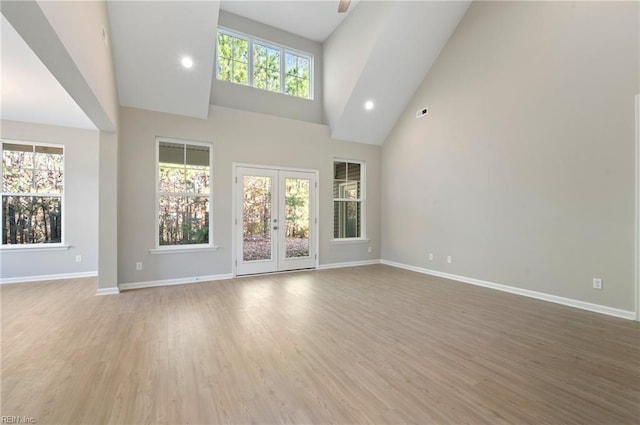 unfurnished living room with a healthy amount of sunlight, baseboards, and wood finished floors