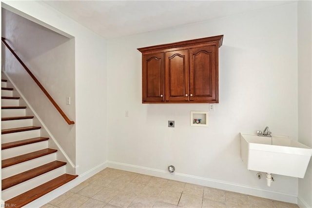 laundry room with hookup for an electric dryer, hookup for a gas dryer, washer hookup, baseboards, and cabinet space