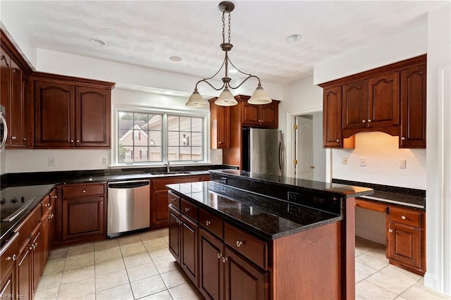 kitchen with a kitchen island, dark stone countertops, decorative light fixtures, stainless steel appliances, and a sink