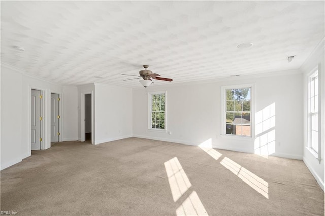 unfurnished room with ornamental molding, light carpet, ceiling fan, and baseboards