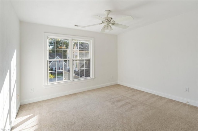 empty room with a wealth of natural light, light colored carpet, and baseboards