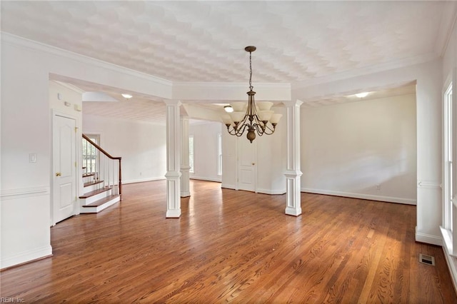 interior space featuring visible vents, stairway, wood finished floors, and decorative columns