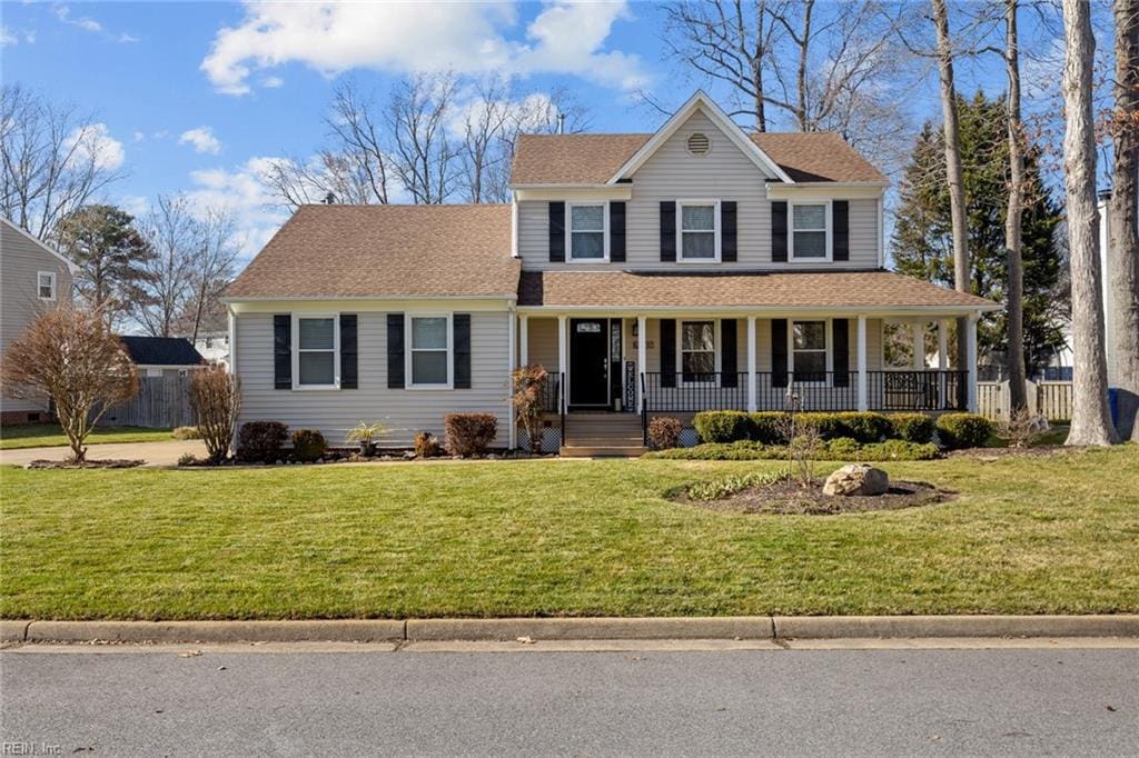 view of front of property with roof with shingles, a porch, and a front yard