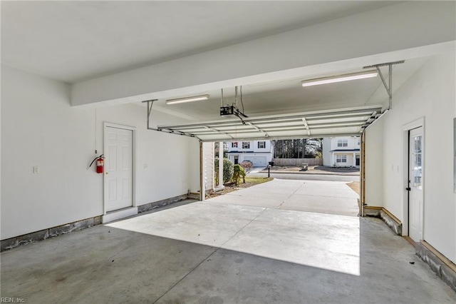 garage with a garage door opener and baseboards