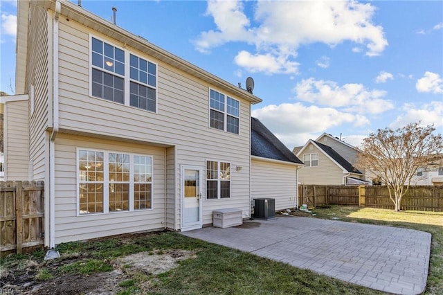 back of house with a patio area, a fenced backyard, central AC unit, and a lawn