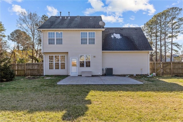 rear view of house with a shingled roof, a lawn, a patio, a fenced backyard, and central AC