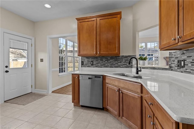 kitchen with dishwasher, a sink, and brown cabinets