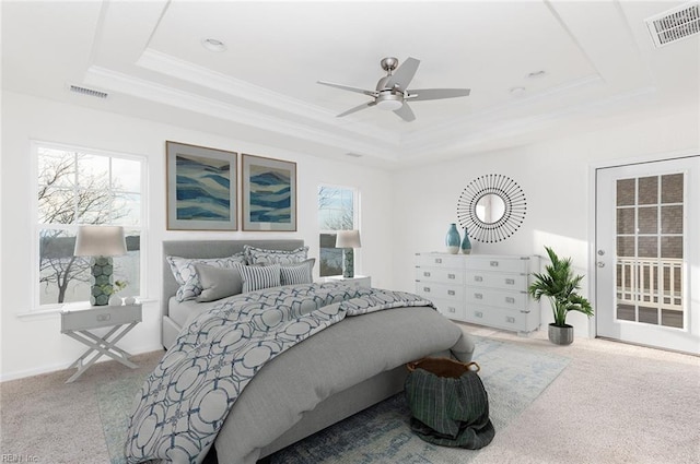 carpeted bedroom featuring access to exterior, a raised ceiling, and visible vents