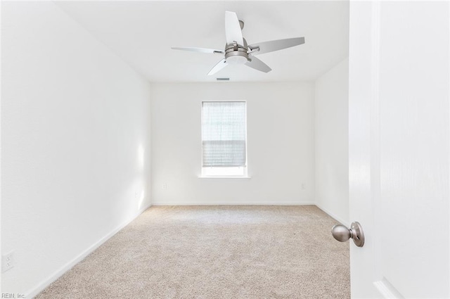 carpeted spare room featuring ceiling fan, visible vents, and baseboards