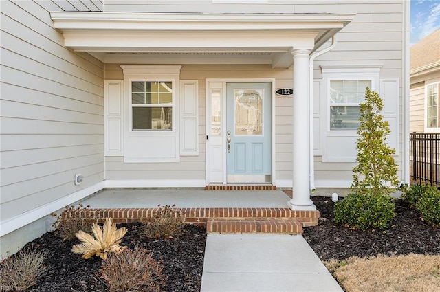 view of exterior entry featuring covered porch