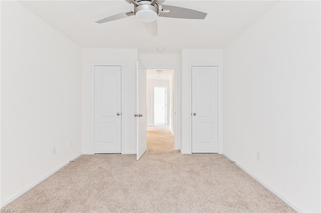 empty room with light carpet, baseboards, and a ceiling fan