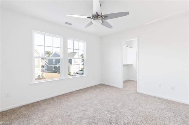 unfurnished room with light carpet, ceiling fan, visible vents, and baseboards