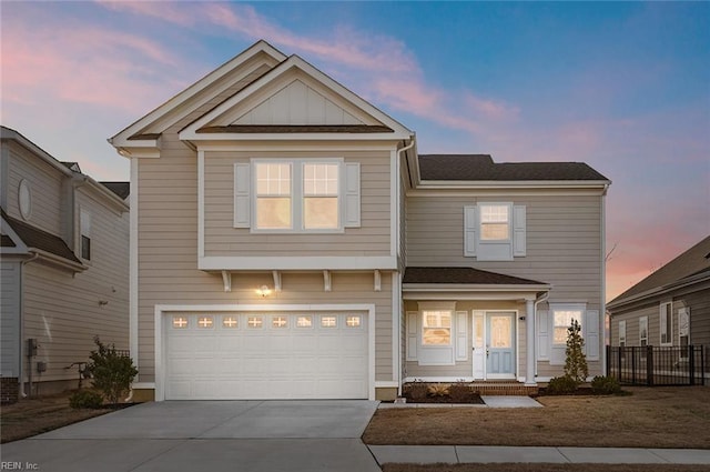 view of front of property featuring board and batten siding, an attached garage, fence, and concrete driveway