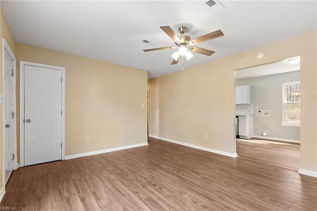 spare room featuring baseboards, visible vents, and wood finished floors