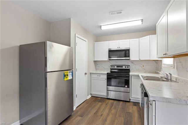 kitchen with dark wood-style floors, tasteful backsplash, appliances with stainless steel finishes, and a sink