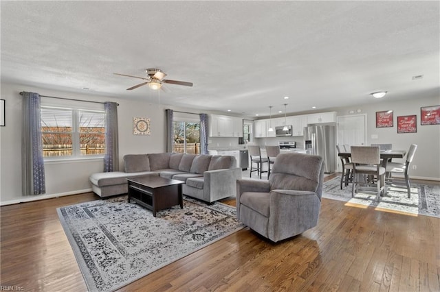 living room with ceiling fan, recessed lighting, wood finished floors, and baseboards