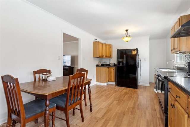 dining area with light wood-style floors, ornamental molding, and baseboards