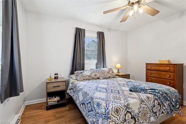 bedroom featuring light wood finished floors, a ceiling fan, and baseboards