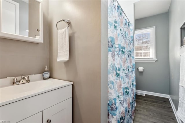 bathroom with vanity, baseboards, and wood finished floors