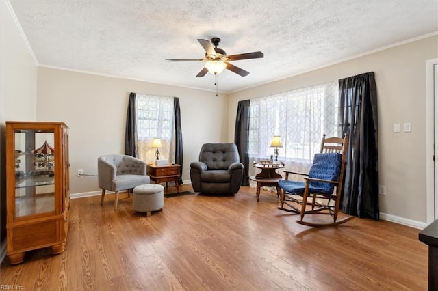 sitting room with plenty of natural light, a textured ceiling, ceiling fan, and wood finished floors