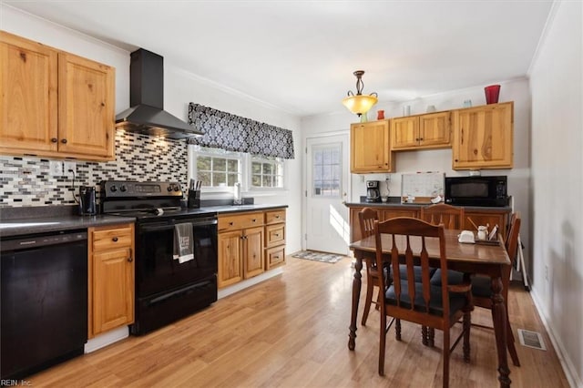 kitchen with visible vents, decorative backsplash, wall chimney range hood, hanging light fixtures, and black appliances