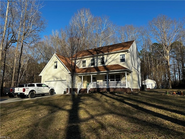 view of front facade featuring a garage, covered porch, driveway, and a front lawn