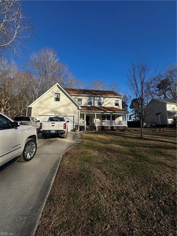 traditional home with covered porch, concrete driveway, and a front yard