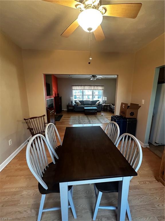 dining room featuring light wood-style floors, baseboards, and a ceiling fan