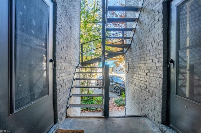 doorway with concrete floors and brick wall