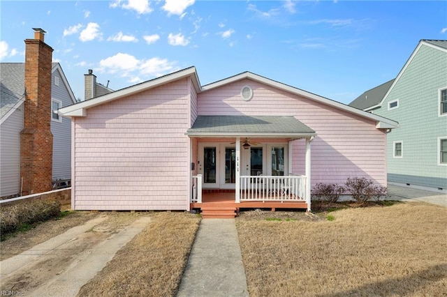 view of front of house featuring covered porch, roof with shingles, and french doors