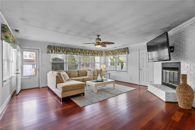 living room with plenty of natural light, a brick fireplace, and wood finished floors