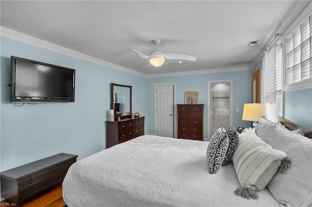 bedroom featuring a closet, visible vents, ornamental molding, a ceiling fan, and ensuite bath