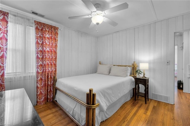 bedroom with visible vents, ceiling fan, and hardwood / wood-style floors