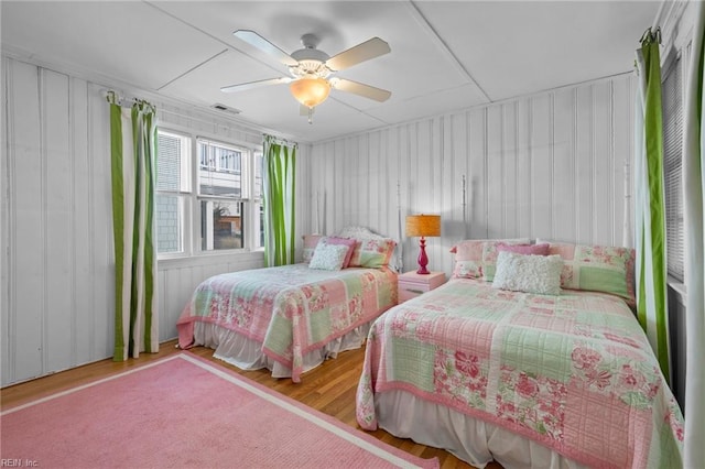 bedroom featuring ceiling fan, visible vents, and wood finished floors