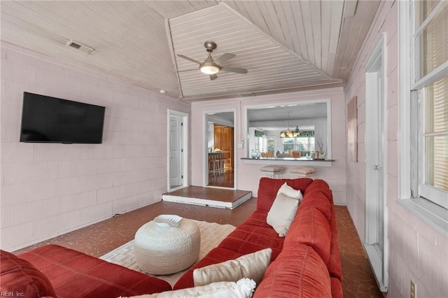 living room with visible vents, wooden ceiling, a ceiling fan, and concrete block wall