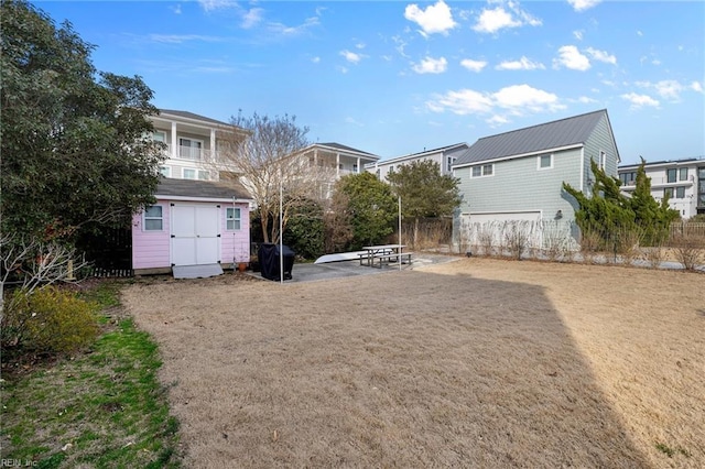 view of yard with an outdoor structure, a patio, a storage shed, and fence