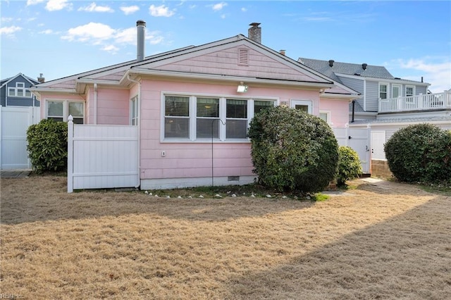 exterior space featuring a front yard, crawl space, fence, and a chimney