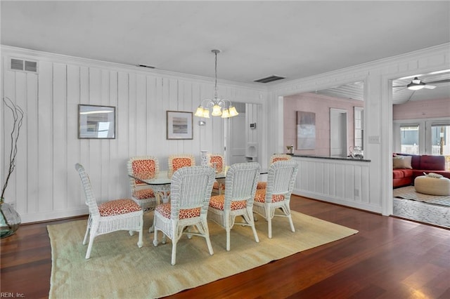 dining room featuring ornamental molding, ceiling fan with notable chandelier, visible vents, and wood finished floors