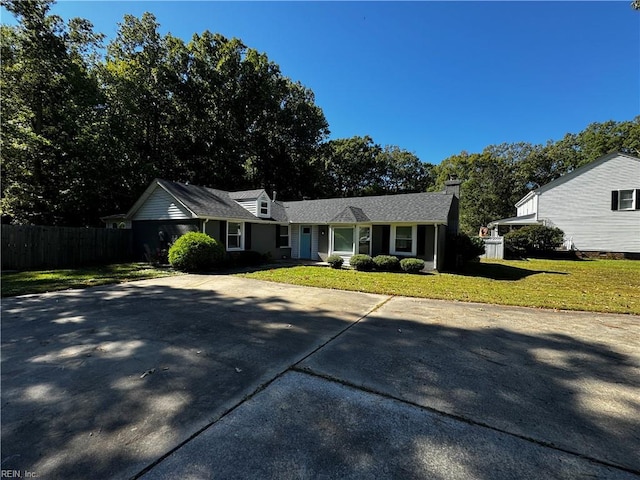 ranch-style home featuring fence and a front lawn