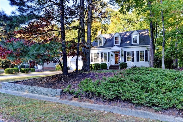 new england style home featuring a garage and driveway