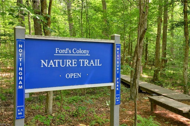 community / neighborhood sign with a wooded view