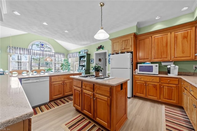 kitchen with white appliances, brown cabinetry, and a kitchen island