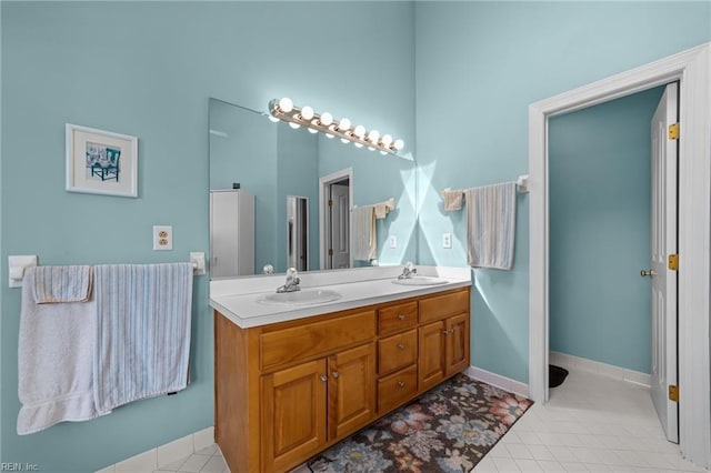 full bath with double vanity, a sink, and tile patterned floors