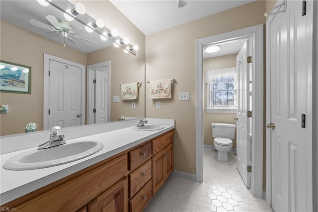 bathroom with tile patterned flooring, a sink, toilet, and a ceiling fan