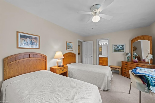 bedroom featuring ceiling fan, ensuite bathroom, and light colored carpet