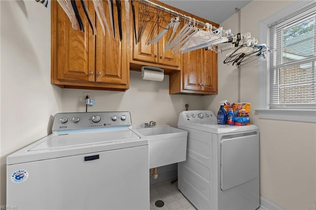 laundry area with a wealth of natural light, cabinet space, light floors, and separate washer and dryer