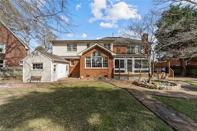 back of property with brick siding, a chimney, a lawn, crawl space, and fence