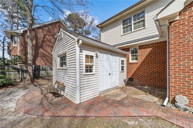 view of outdoor structure featuring fence and an outbuilding