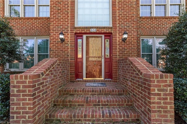 view of exterior entry featuring brick siding